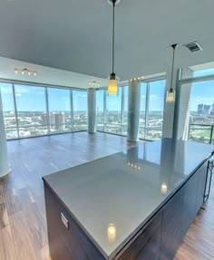 an empty room with high ceilings and floor to ceiling glass windows overlooking the cityscape