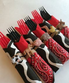 the forks are decorated with farm animals and red, black, and white napkins