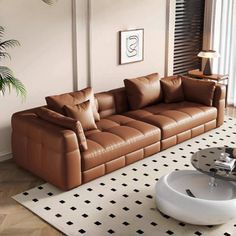 a brown leather couch sitting on top of a white rug