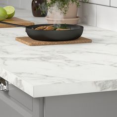 a black pan sitting on top of a counter next to a cutting board with food in it