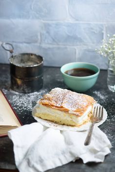 a table topped with a plate of food next to a cup of coffee and an open book