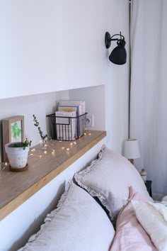 a bed with pillows and lights on the headboard