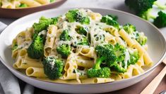 a white bowl filled with pasta and broccoli