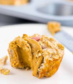 a close up of a muffin on a plate with a bite taken out of it