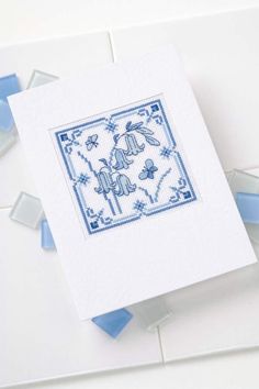 a blue and white cross stitched card with an elephant on it's back