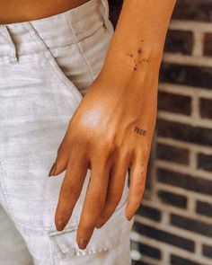 a woman's left hand with the word love tattooed on her right wrist and fingers