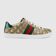 "Find GUCCI Ace Sneaker With Bees Gg Canvas on Editorialist. Since its debut, the Ace sneaker has become a mainstay of the House's collections. The retro-looking design is inspired by a Gucci sneaker from the 1970s, with the Web stripe along the sides. A metallic gold bees print embellishes the low-top silhouette. Beige/ebony GG Supreme canvas with gold bees print Green and red Web detail, Red leather detail on the back of one shoe and green the other, Rubber sole, Flat,.8\" height, Made in Italy, This style runs big, we recommend sizing down" Gucci Ace Sneakers, Gucci Gifts, Striped Sneakers, Gucci Sneakers, Bee Print, Sneakers For Women, Leather Trainers, Gucci Shoes, Designer Sneakers