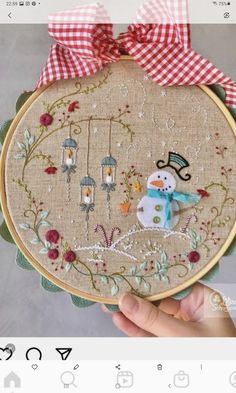 someone is holding up a small embroidery project