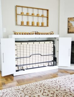 a living room with a white entertainment center in the middle and a rug on the floor