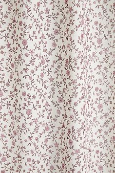 a white shower curtain with pink flowers on it