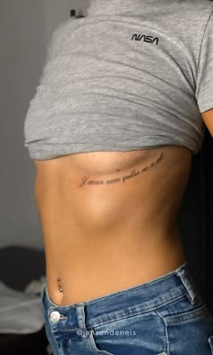 a woman with a small tattoo on her stomach and the words venus are written in cursive writing