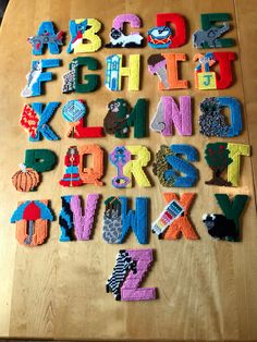 a wooden table topped with lots of different types of letters and numbers made out of felt