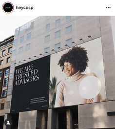 a large advertisement on the side of a building with an image of a woman holding a white frisbee