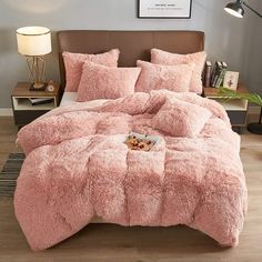 a bed with pink comforter and pillows