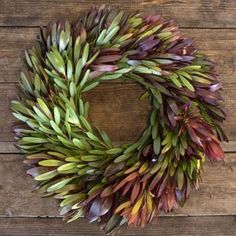 a wreath made out of leaves sitting on top of a wooden table