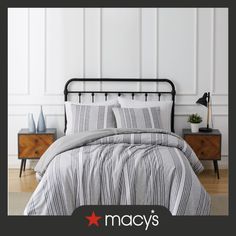 an image of a bed with grey and white striped comforter set on top of it