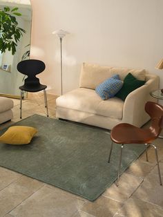 a living room with two couches and a rug on the floor in front of a mirror