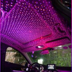 the interior of a car with purple lights on it's ceiling and steering wheel