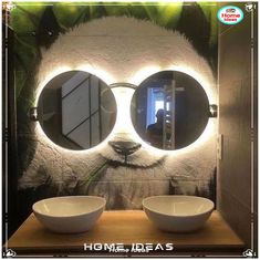 two white bowls sitting on top of a wooden counter in front of a wall mounted mirror