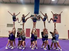 a group of cheerleaders doing stunts in a gym