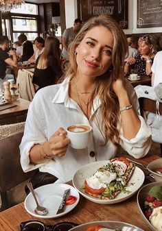 a woman sitting at a table with food in front of her