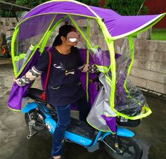 a woman standing next to a scooter with a purple and green cover on it