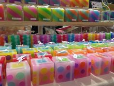 many different colored candles on display in a store