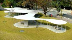 an aerial view of a large white structure in the middle of a park