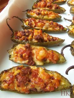 several stuffed peppers are lined up on a white plate and ready to be cooked in the oven