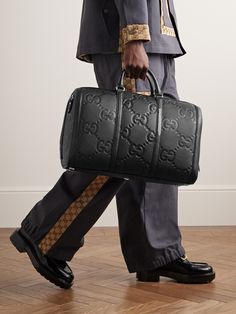 Gucci's duffle bag has been crafted in Italy from monogrammed full-grain leather and can be locked for peace of mind while travelling. It opens wide for easy access to your belongings and comes with a detachable shoulder strap. Get the matching briefcase to look polished on business trips. Duffle Bag For Men, Gucci Travel Bag, Merch Inspiration, Men Runway, Mens Designer Bag, Kash Doll, Gucci For Men, Gucci Collection, Mens Bag