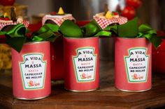 three tins with green leaves in them sitting on a table