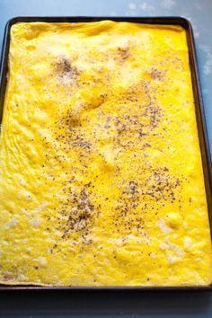 a pan filled with food sitting on top of a blue counter next to a knife