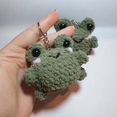 a hand holding two small stuffed animals in it's palm, with eyes on them