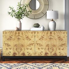 a living room with a large mirror and vases on top of the sideboard