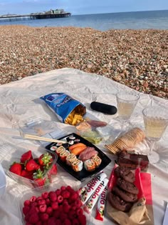 a table with food and drinks on it at the beach