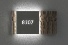 a wall mounted square light with the word'087'lit up in front of it