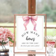 a sign that says how many bows are in the jar on a table with vases and flowers