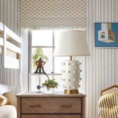 a bedroom with a bed, chair and lamp in it's corner next to a window