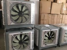 three air conditioners sitting next to each other on pallets in front of boxes