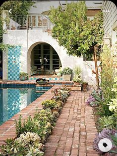 an image of a house with a pool in the middle and landscaping around it on the other side