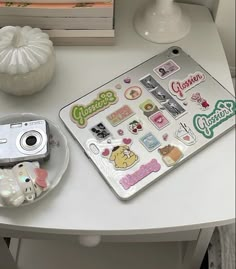 a white table topped with a camera and stickers