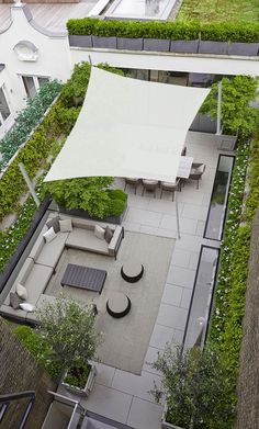 an aerial view of a rooftop garden with seating and pergolated roofing area