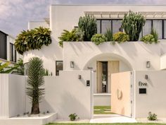 a white house with plants growing on the windows and doors that say live in front of it