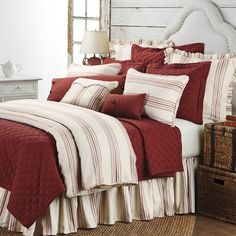 a bed with red and white comforters in a room