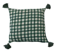 a green and white checkered pillow with tassels