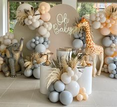 balloons and giraffes are set up in front of a backdrop for a baby shower