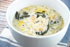 a white bowl filled with soup on top of a blue and white towel