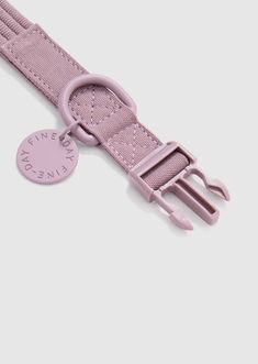 a pink strap with a metal buckle on the end and a small tag attached to it