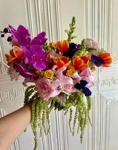 a person holding a bouquet of flowers in their hand