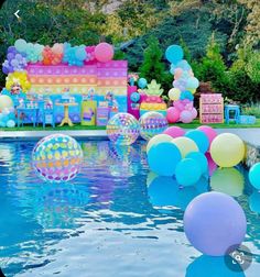 an outdoor party with balloons and decorations in the swimming pool at a children's birthday party